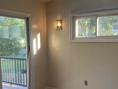 Interior bedroom painting project featuring smooth light gray walls, crisp white trim, and clean professional finishes