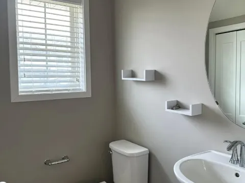 Powder room painting project with smooth gray walls, white fixtures, and modern finishes