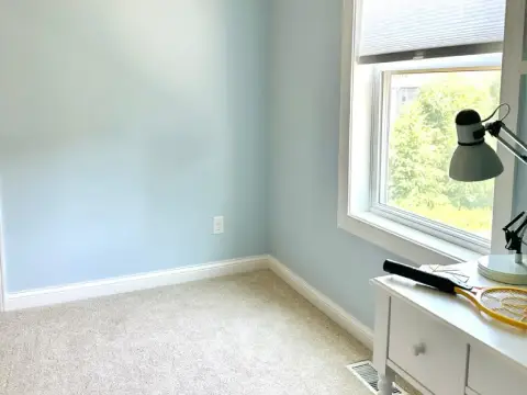 Freshly painted entryway with warm gray walls, white trim, and luxury vinyl plank flooring
